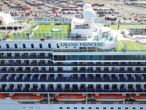 Passengers look out as the Grand Princess cruise ship docks at the Port of Oakland in Oakland, California on March 9, 2020.