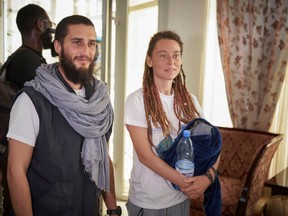 Italian Luca Tacchetto and Canadian Edith Blais are greeted by officials as they arrive at the airport in Bamako on March 14, 2020, after their release by UN peacekeepers.