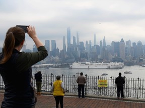 In this file photo people watch as the USNS Comfort medical ship moves up the Hudson River as it arrives on March 30, 2020 in New York as seen from Weehawken, New Jersey.