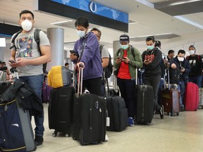 People wait to check-in at the Qatar Airways counter amid coronavirus fears at Miami International Airport on March 15, 2020 in Miami, Florida.