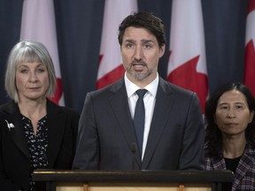 Minister of Health Patty Hajdu and Chief Medical Officer Theresa Tam (right) look on as Prime Minister Justin Trudeau responds to a question during a news conference on the coronavirus situation, in Ottawa, Wednesday, March 11, 2020.