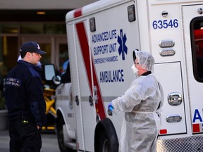 A firefighter (left) and a paramedic (right) speak outside the Lynn Valley Care Centre, a seniors care home which housed a man who was the first in Canada to die after contracting novel coronavirus, is seen in North Vancouver, British Columbia, Canada March 9, 2020. B.C. has reported that three more have died after contracting the novel coronavirus.