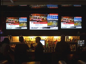 People drink at a bar on Danforth Avenue in Toronto, Ontario