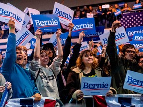 Supporters of Democratic White House hopeful Vermont Senator Bernie Sanders display posters and cheer during a campaign rally at the Virginia Wesleyan University Convocation Hall on February 29, 2020 in Virginia Beach, Virginia.