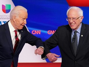 Democratic presidential hopefuls former U.S. vice-president Joe Biden and Sen. Bernie Sanders greet each other with an elbow bump before the start of a Democratic Party 2020 presidential debate in Washington on March 15, 2020.