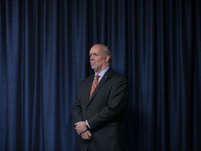 Premier John Horgan listens to questions over the phone from media as he joins Minister Mike Farnsworth to provide government measures in regards to the COVID-19 pandemic during a press conference in the press gallery at Legislature in Victoria, B.C., on Thursday March 26, 2020.