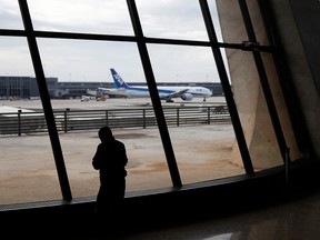 A man stands in a check-in area at Dulles International Airport in Dulles