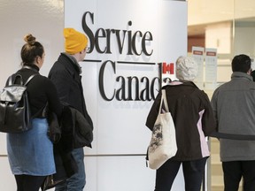 People line up at a Service Canada office in Montreal on Thursday, March 19, 2020.