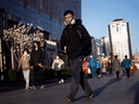 A commuter wears a protective mask as businesses are starting to revert to a normal work routine after an outbreak of the COVID-19 coronavirus, in Beijing, China, March 27, 2020.