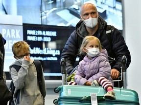 Travellers, wearing masks, arrive on a direct flight from China at Vancouver International Airport in Richmond,B.C., Jan. 24, 2020.