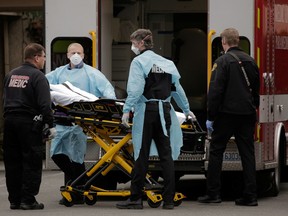 Medics prepare to transfer a patient to an ambulance from a long-term care facility linked to two confirmed coronavirus cases in Kirkland, Wash., on March 1, 2020.