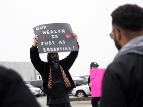 Christian Smalls holds a sign at Amazon building during the outbreak of the coronavirus disease (COVID-19), in the Staten Island borough of New York City, U.S., March 30, 2020.