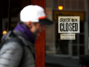 A pedestrian walks by a closed sign on the door of a restaurant on March 17, 2020 in San Francisco, California.