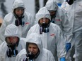 Servpro cleaners wear respirators, disposable suits and gloves as they enter Life Care Center of Kirkland