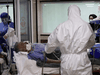 Emergency medical staff transfer a patient with the COVID-19 coronavirus to Masih Daneshvari Hospital, in Tehran, Iran, March 30, 2020.