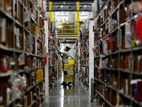 A worker gathers items for delivery from the warehouse floor at Amazon's distribution center in Phoenix, Arizona, November, 2013.