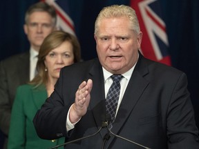 Ontario Premier Doug Ford answers questions as Health Minister Christine Elliott and Finance Minister Rod Phillips listen at Queen's Park in Toronto on Monday, March 23, 2020.