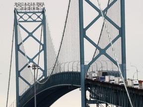 Vehicles move across the Ambassador Bridge between Detroit and Windsor, Ontario as shown from Detroit on March 16, 2020. Officials in Windsor, Ont., say the decision to partially close the Canada-U.S. border to slow the spread of COVID-19 is for the best despite the inevitable impact it will have on the local economy. Located on the north shore of the Detroit River, Windsor boasts the busiest crossing between the two countries.