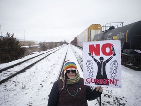 A protester holds a placard as supporters of the Wet'suwet'en hereditary chiefs demonstrate at Macmillan Yard in Toronto, Saturday, Feb. 15, 2020. In the last month, Indigenous people across the country set up barricades on train tracks, roads and bridges, in solidarity with Wet'suwet'en Nation hereditary chiefs, some of whom object to the construction of a natural-gas pipeline through their traditional territory.