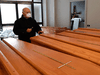 A priest, wearing a face mask, blesses coffins of the deceased in a mortuary on March 25, 2020 in Albino, Italy, during the country’s lockdown following the COVID-19 pandemic.