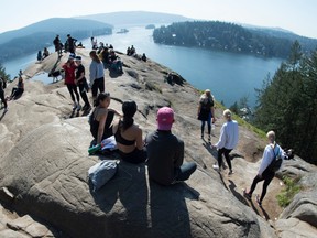 Hikers fail to practice social distancing as they gather at the top of popular hiking trail, Quarry Rock in Deep Cove in North Vancouver Friday, March 20, 2020.