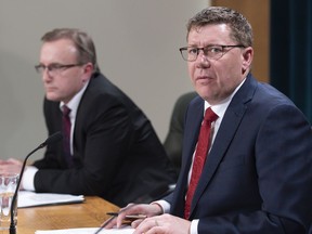 Scott Moe, premier of Saskatchewan, speaks while Jim Reiter, Minister of Health, looks on at a COVID-19 news update at the Legislative Building in Regina on Wednesday March 18, 2020. Saskatchewan is reporting its first two deaths from COVID-19.