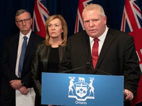 Ontario Premier Doug Ford answers questions as Minister of Health Christine Elliott and Ontario Chief Medical Officer of Health Dr. David Williams, left, listen in during a news conference at the Ontario Legislature in Toronto on Monday, March 16, 2020.