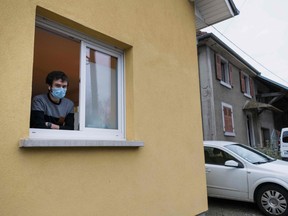 Jonathan Peterschmitt, a doctor infected with COVID-19, the new coronavirus, poses at the window of his medical office in Bernwiller, eastern France, on March 4, 2020.