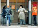 A nurse speaks to people asking for a COVID-19 test at St. Michael's Hospital in Toronto, March 30, 2020.
