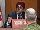 National Defence Minister Harjit Sajjan speaks during a news conference as Chief of Defence Staff Jonathan Vance listens, in Ottawa on March 30, 2020.