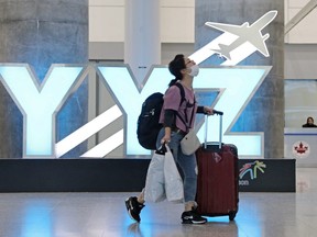 A traveller passes a YYZ airport code sign in the international arrival lounge amid a growing global number of coronavirus cases at Pearson Airport in Toronto, March 13, 2020.