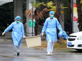 Medical staff carry a box as they walk at the Jinyintan hospital, where the patients with pneumonia caused by the coronavirus are being treated, in Wuhan, Hubei province, China.