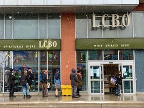 Customers observe social distancing protocols as they line up to enter a LCBO store on Bank Street during the COVID-19 outbreak.