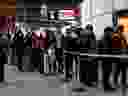 Travellers queue at an airport information desk at Paris-Charles-de-Gaulle airport after a US 30-day ban on travel from Europe due to the COVID-19 spread in Roissy-en-France on March 12, 2019.