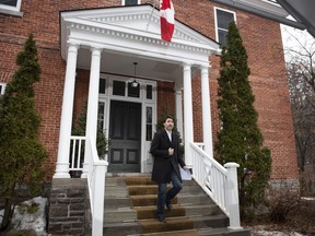 Prime Minister Justin Trudeau looks up at the falling rain as he arrives for his daily press conference on COVID-19 in front of his residence at Rideau Cottage, on the grounds of Rideau Hall in Ottawa, on Sunday, March 29, 2020.