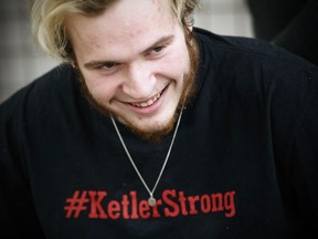 Reese Ketler, a 19-year-old who was paralyzed during a hockey game in December, wears a necklace with his jersey number and a t-shirt with his hashtag as works through his rehabilitation with physiotherapist Kevin Stewart at the Health Sciences Centre in Winnipeg, Thursday, March 5, 2020.