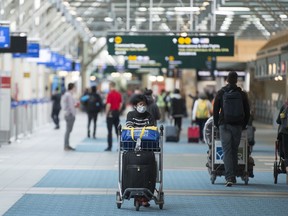 Travellers are seen at Vancouver International Airport in Richmond, B.C. Friday, March 13, 2020.
