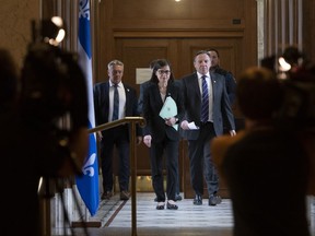 Quebec Premier Francois Legault, right, and Quebec Health Minister Danielle McCann, centre, walk to a news conference on the COVID-19 pandemic, Monday, March 30, 2020 at the legislature in Quebec City.