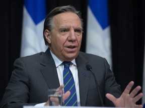 Quebec Premier Francois Legault, right, responds to reporters questions during a news conference on the COVID-19 pandemic, Wednesday, March 25, 2020 at the legislature in Quebec City.