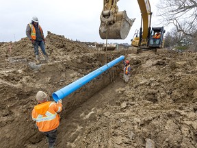 Construction workers install a new water main in London, Ont., on March 6.