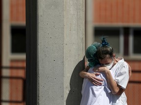 Medical wokers hug each other outside the emergency rooms at Severo Ochoa Hospital during the COVID-19 outbreak in Leganes, Spain, on March 26, 2020.