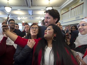 Prime Minister Justin Trudeau poses for photos with new Canadians as he attends a citizenship ceremony at Acadia University in Wolfville, N.S. on Tuesday, March 3, 2020.