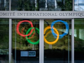 The Olympic Rings logo are reflected in the windows of the headquarters of the International Olympic Committee (IOC) in Lausanne on March 18, 2020, as doubts increase over whether Tokyo can safely host the summer Games amid the spread of the COVID-19.