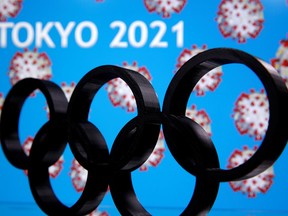 A 3D printed Olympics logo is seen in front of displayed  "Tokyo 2021"  words in this illustration taken March 24, 2020.