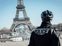 A police officer stands guard near the Eiffel Tower during citizen movement restrictions and coronavirus containment measures in Paris, France, on March 24, 2020.