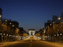 An empty Champs-Elysees Avenue and the Arc de Triomphe in Paris, at night on March 24, 2020, on the eight day of a lockdown aimed at curbing the spread of the COVID-19 coronavirus.