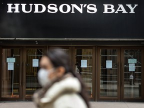 A pedestrian wearing a mask walks past the entrance to a Hudson’s Bay store in Toronto during ongoing COVID-19 crisi, on March 19.