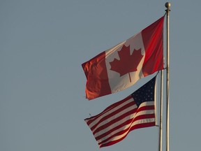The Canadian and American flags are seen on top of the Peace Arch is at the Canada/USA border in Surrey, B.C. Friday, March 20, 2020. Prime Minister Justin Trudeau will announce today that Kirsten Hillman is being named the permanent envoy to the U.S., a role she has been performing on an acting basis since September.THE CANADIAN PRESS/Jonathan