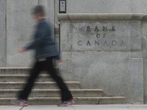 A woman walks past the Bank of Canada bulding in Ottawa, Wednesday September 6, 2017. The Bank of Canada is cutting its key interest target by half a percentage point to 0.25 per cent in an unscheduled rate announcement.