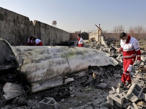 In this Wednesday, Jan. 8, 2020 photo, rescue workers search the scene where a Ukrainian plane crashed in Shahedshahr, southwest of the capital Tehran, Iran. The COVID-19 pandemic is presenting new challenges to the already-frustrated families of 55 Canadians who were killed when their plane was shot down by Iran in January.